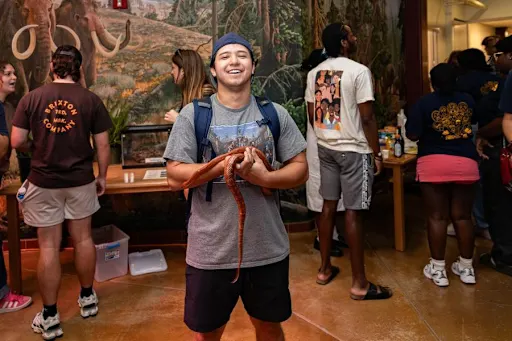 Student holding snakes